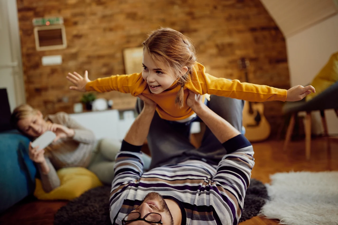Father playing with his daughter in a warm family home