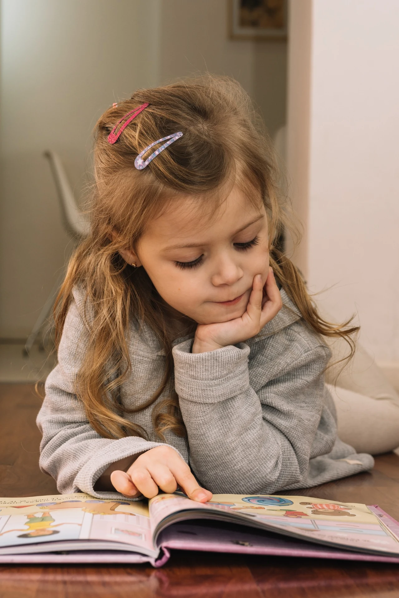 Young girl reading a picture book at home
