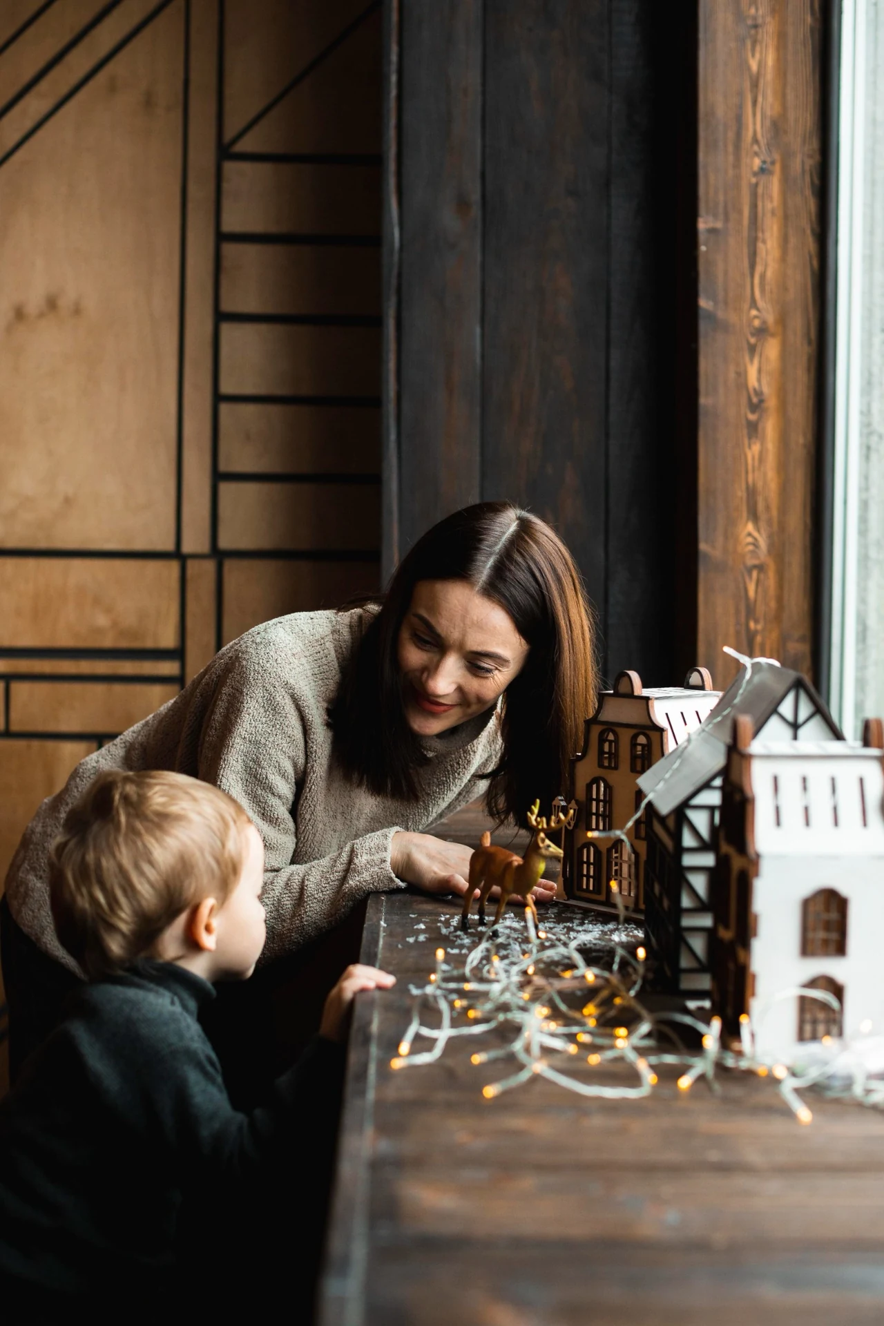 Mother and child playing together with a model home