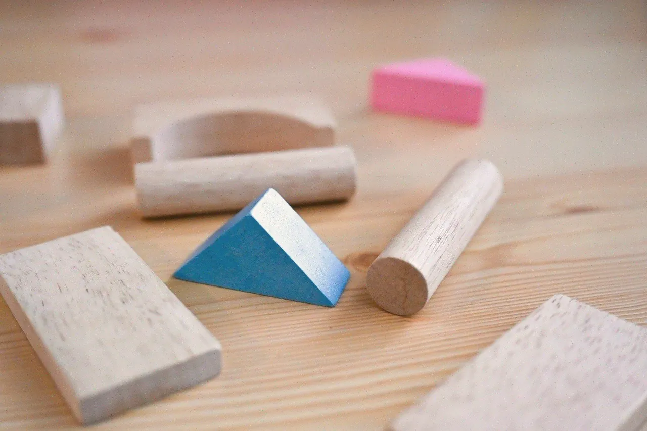 Wooden building blocks on a light timber table