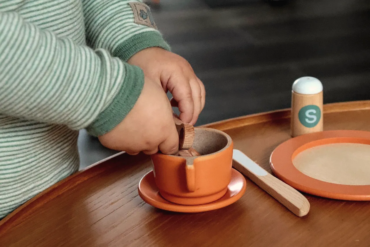 Hands preparing a warm drink at a wooden table